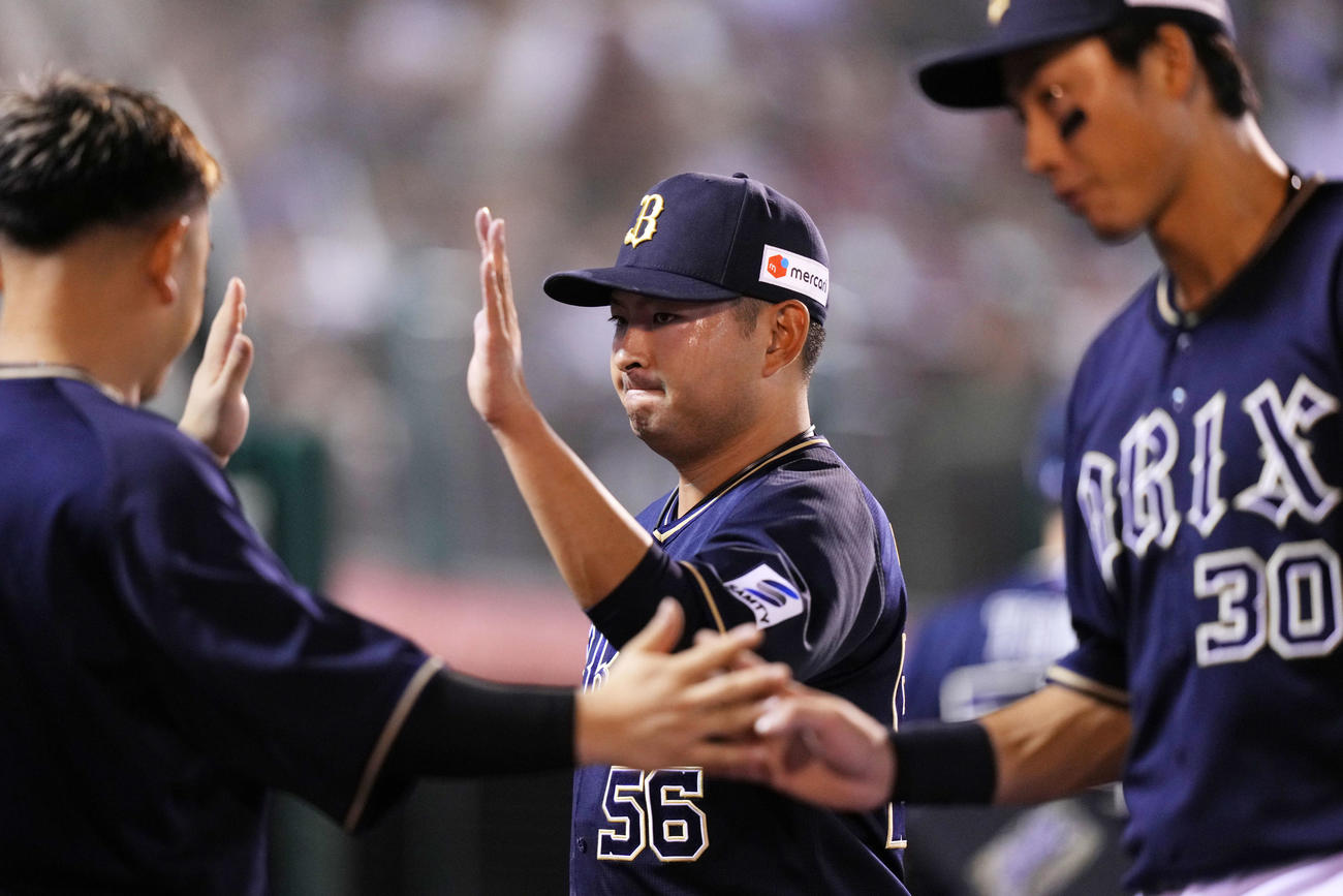 楽天対オリックス　7回裏を無失点に抑えタッチを交わすオリックス小木田（中央）（撮影・横山健太）