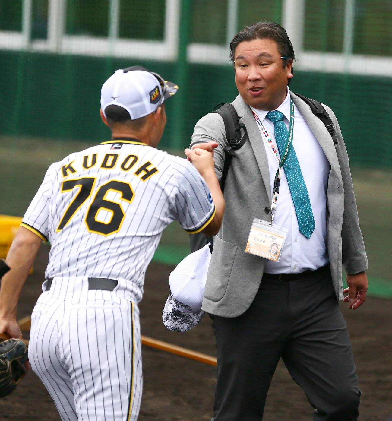 阪神工藤2軍外野守備走塁コーチ（手前）とグータッチする日刊スポーツ評論家の里崎智也氏は（撮影・上山淳一）