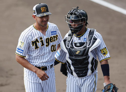 打撃投手での登板を終えた阪神ゲラ（左）と言葉を交わす梅野（撮影・前田充）