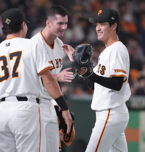 巨人対阪神　7回表を無失点に抑え、グリフィン（中央）らに迎えられ笑顔の巨人西舘（撮影・鈴木みどり）