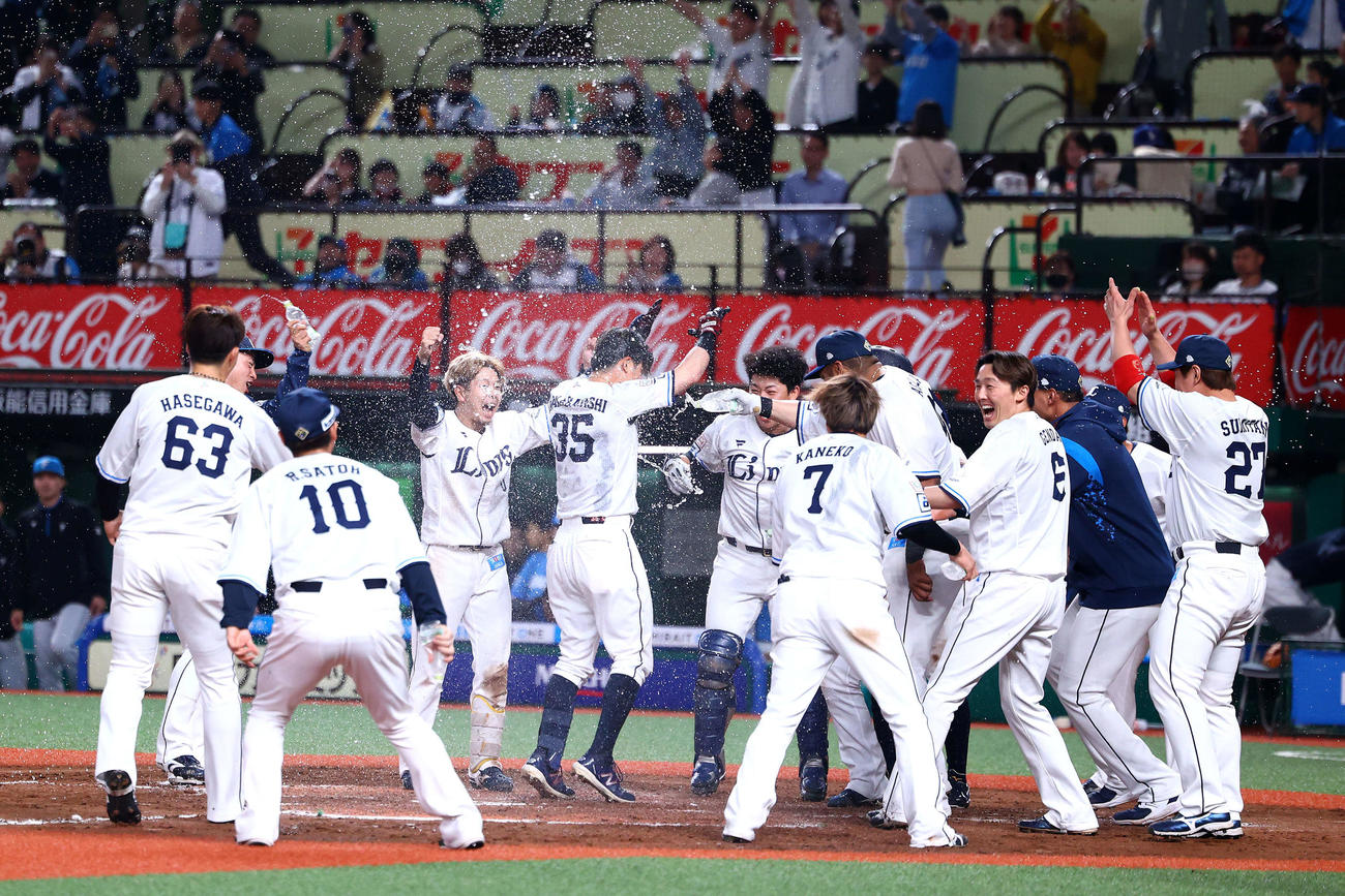 西武対日本ハム　9回裏西武2死二塁、左越えサヨナラ2点本塁打で生還し、チームメートと歓喜する若林（中央）（撮影・河田真司）
