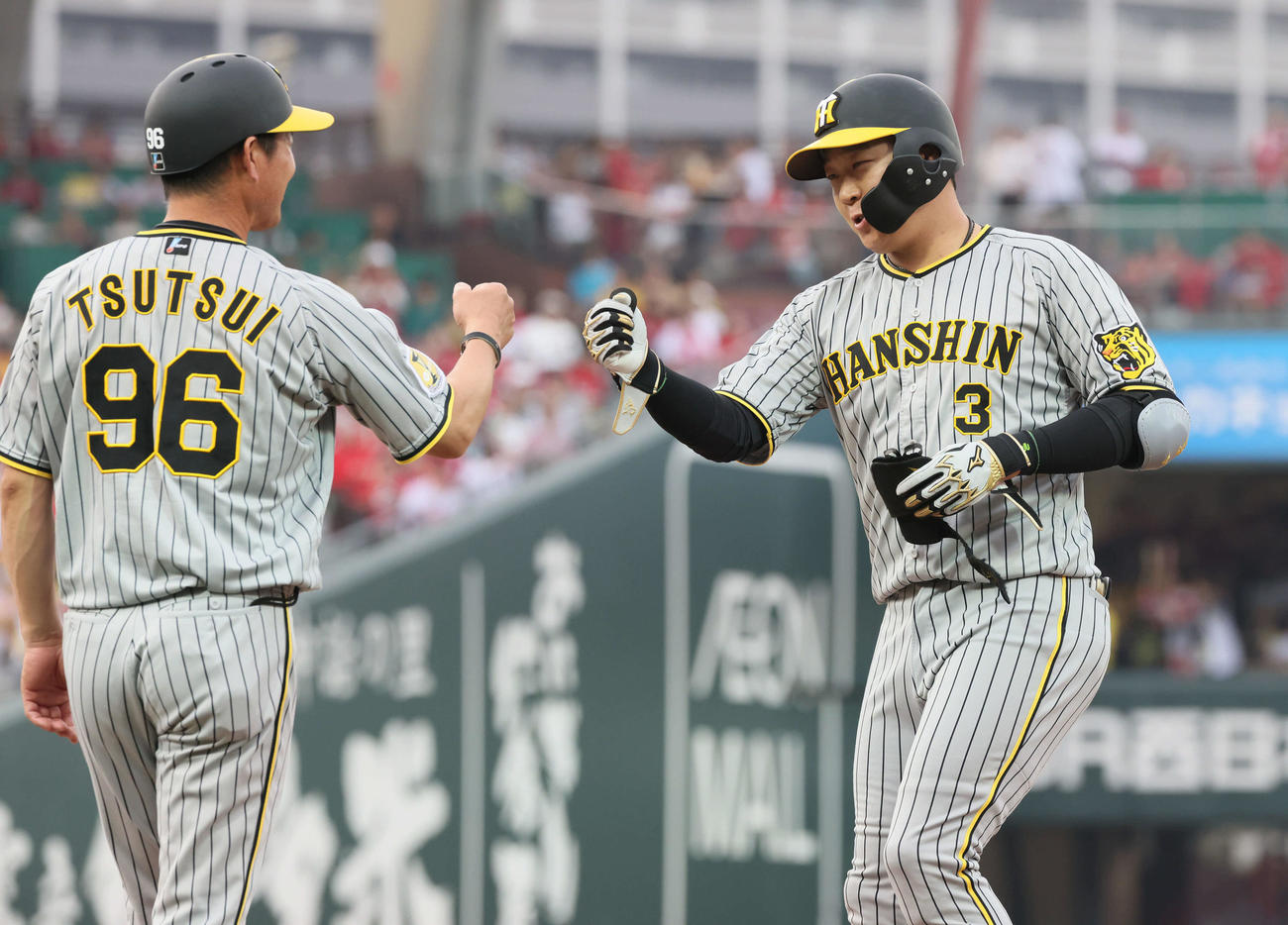 広島対阪神　1回表阪神2死二塁、大山（右）は先制右適時打を放ち、筒井コーチとグータッチ（撮影・加藤孝規）