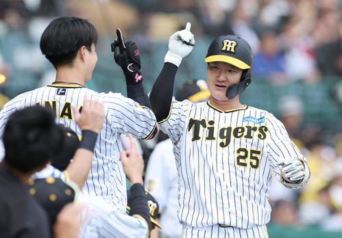 阪神対巨人　4回裏阪神無死、左越えソロ本塁打を放ちナインに迎えられる渡辺（右）（撮影・前田充）
