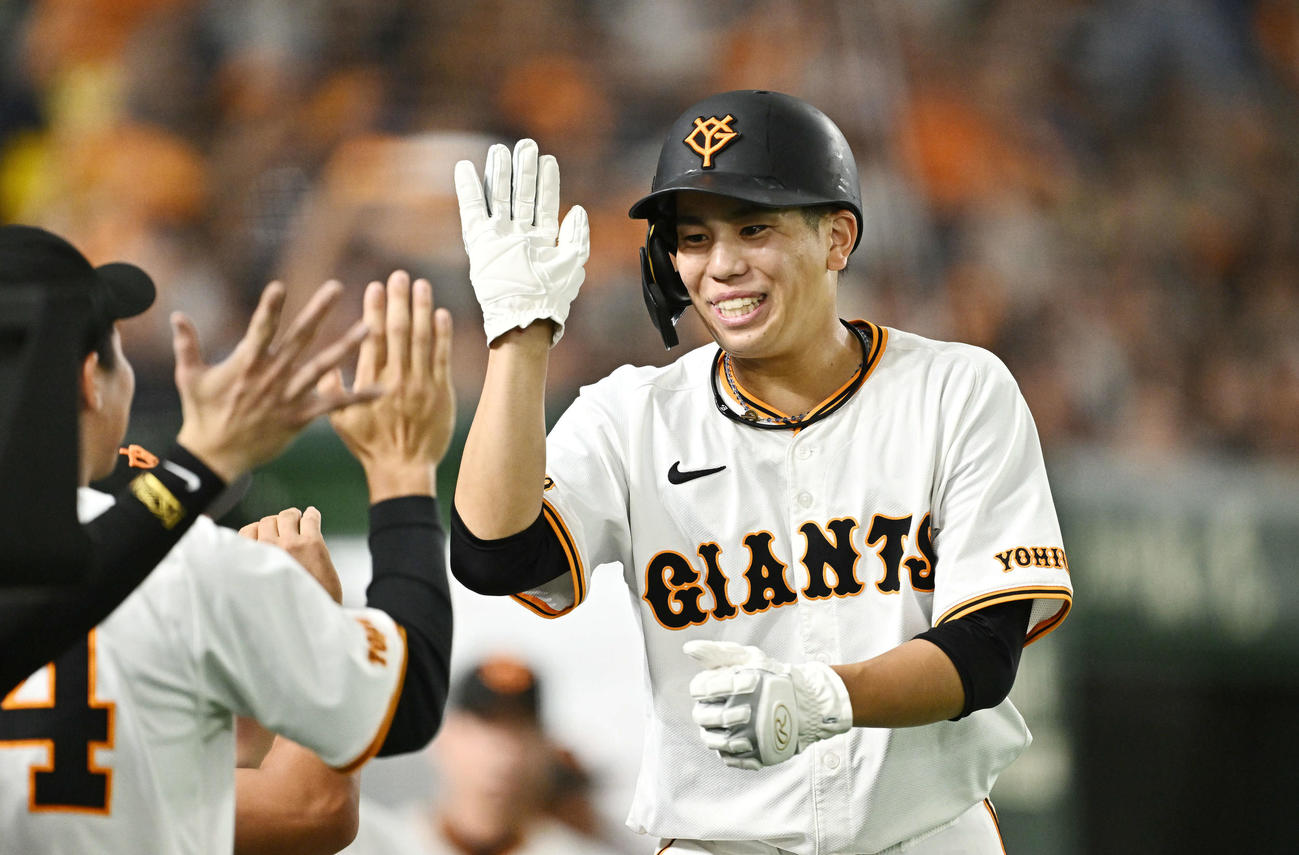 巨人対DeNA 6回裏巨人2死二塁、グリフィンの適時二塁打で生還した門脇（右）はチームメートとタッチをかわす（撮影・滝沢徹郎）