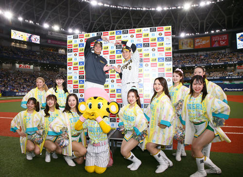 阪神対ヤクルト　「TORACO DAY」で勝利を飾ったヒーローの才木（左）と木浪はタイガースガールズと一緒にポーズを決める（撮影・上山淳一）