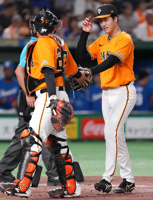 巨人対中日　3回表を終え、岸田（左）とタッチを交わす巨人西舘（撮影・鈴木みどり）