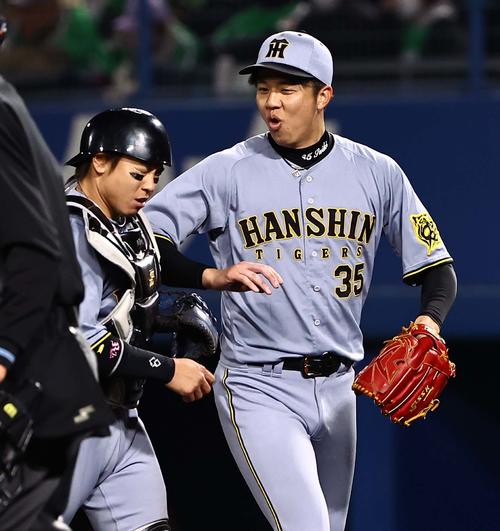 ヤクルト対阪神　6回裏ヤクルト2死一塁、長岡の捕ゴロを処理した梅野（左）に笑顔を見せる才木（撮影・上田博志）