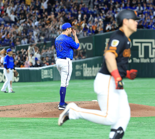 巨人対DeNA 5回裏巨人2死二塁、岡本（手前）に2点本塁打を許し、汗をぬぐうバウアー（撮影・浅見桂子）