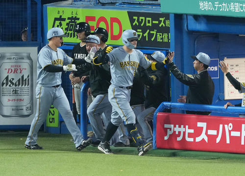 ヤクルト対阪神　8回表阪神無死二塁、佐藤輝（中央）は2点本塁打を放ち藤川監督（右）にタッチで迎えられる（撮影・足立雅史）
