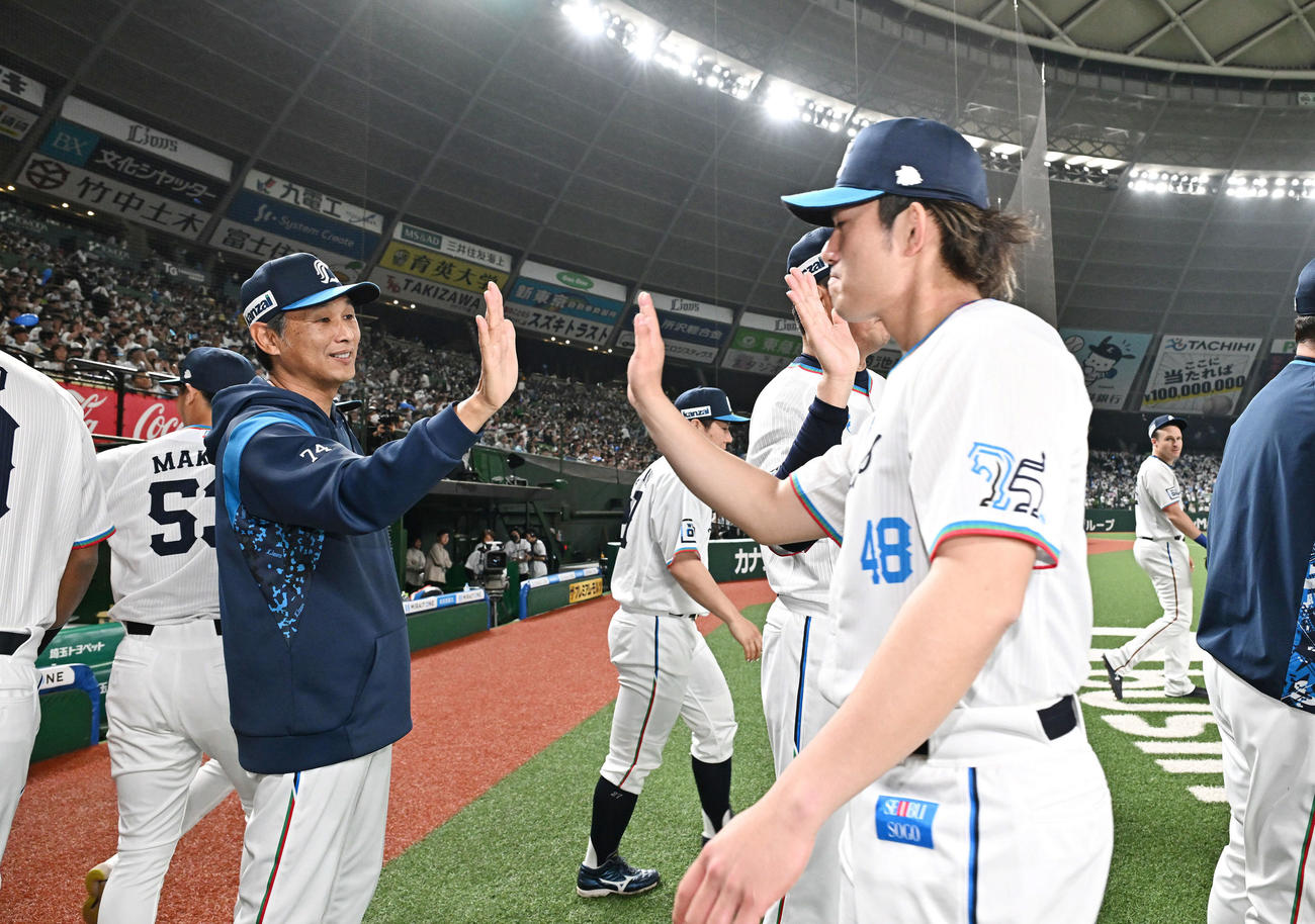 西武対ソフトバンク　試合後、西武西口監督（左）は勝利投手の西武今井とタッチをかわす（撮影・滝沢徹郎）