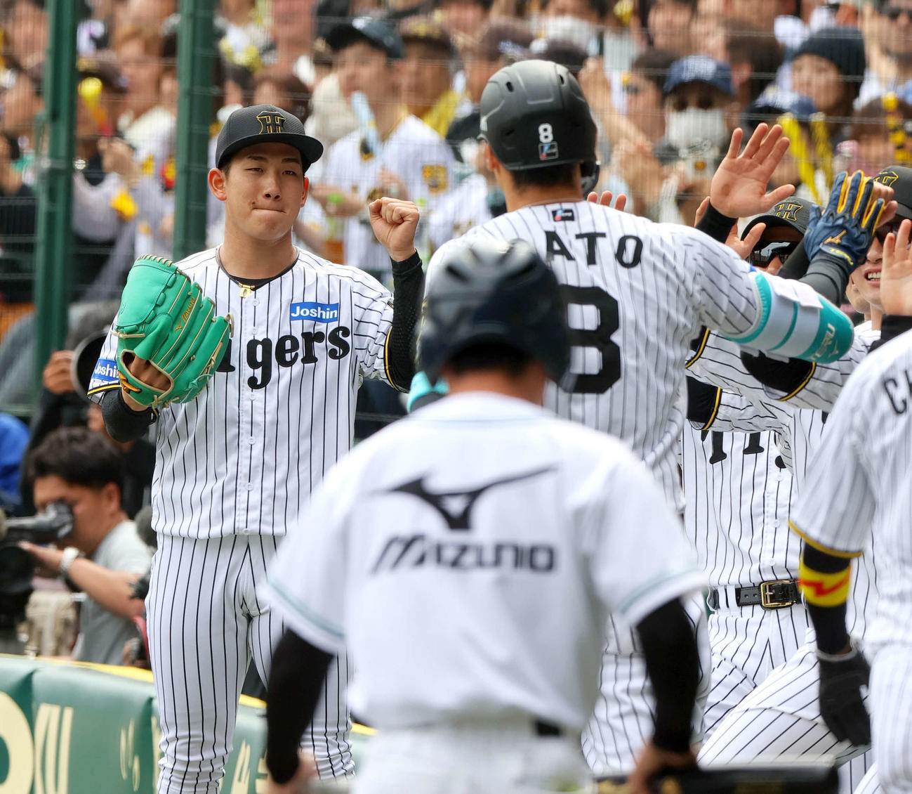 阪神対広島　1回裏阪神1死二塁、先制の中越え2点本塁打を放った佐藤輝（手前）を出迎える伊原（撮影・上山淳一）
