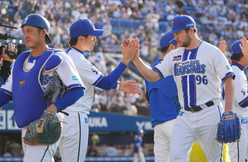 DeNA対巨人　完封勝利のDeNAバウアー（右）は三浦監督（中央）とタッチを交わす（撮影・垰建太）