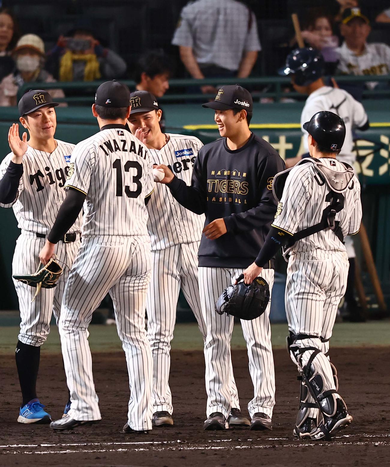 阪神対DeNA 2勝目をあげた門別（右から2人目）はは岩崎から勝利球を受け取り笑顔を見せる（撮影・上田博志）