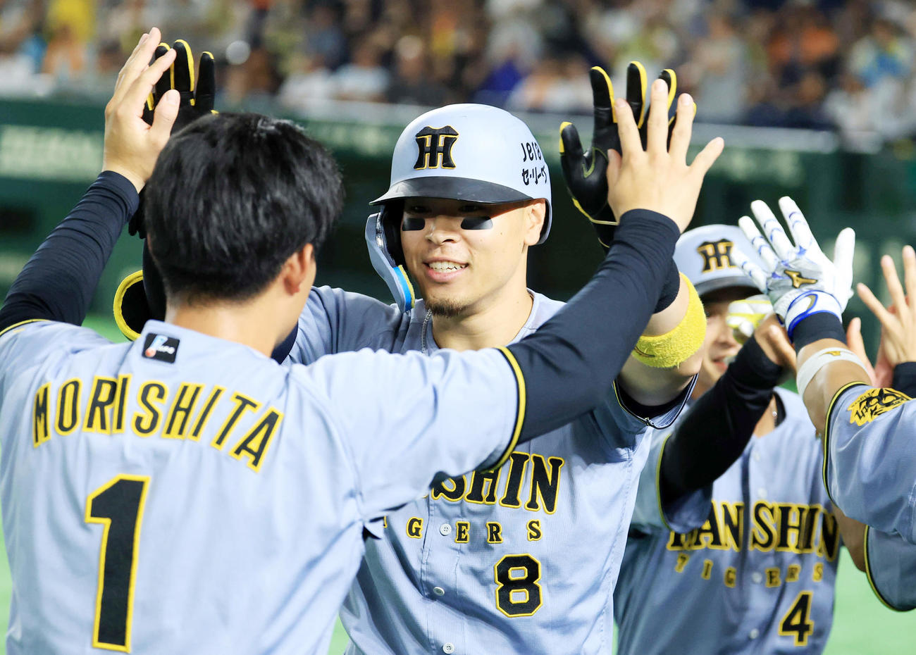 巨人対阪神　11回表阪神1死一塁、佐藤輝（中央）は2点本塁打を放ち森下らナインとハイタッチ（撮影・浅見桂子）