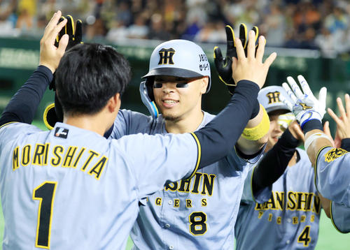 巨人対阪神　11回表阪神1死一塁、佐藤輝（中央）は2点本塁打を放ち森下らナインとハイタッチ（撮影・浅見桂子）