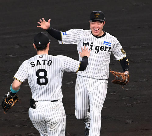 リーグ優勝を果たし佐藤輝（左）とハイタッチをする大山（撮影・石井愛子）