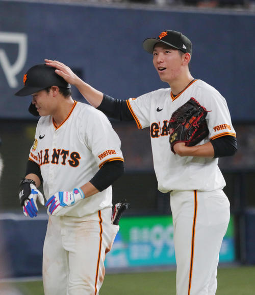 巨人対ヤクルト　4回裏巨人2死、戸郷（右）は右越え本塁打を放った中山を祝福する（撮影・上山淳一）