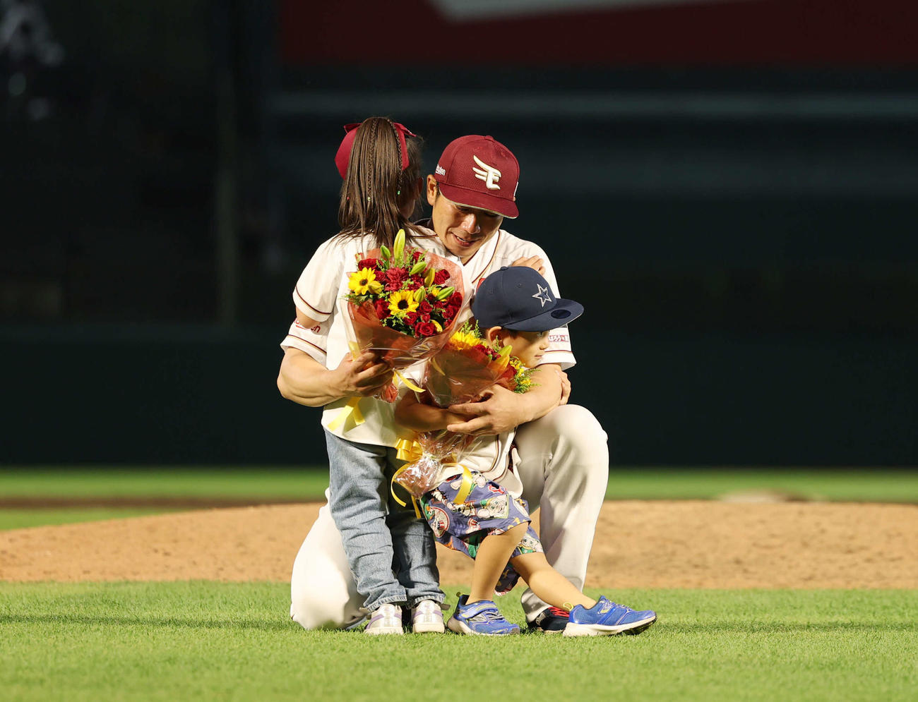 楽天対西武　引退セレモニーで子供とハグをする楽天岡島（撮影・増田悦実）