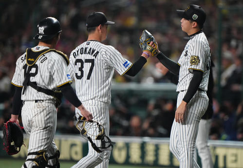 阪神対ソフトバンク　6回表を終えベンチへ戻る及川（中央）を迎える阪神才木（右）（撮影・鈴木みどり）