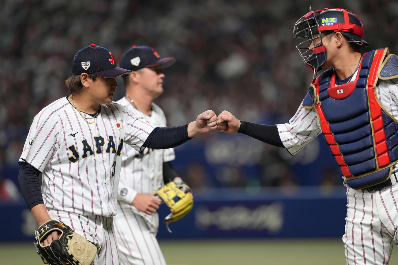 日本対中日　1回を終え、タッチをする宮城（左）と若月（撮影・井上学）