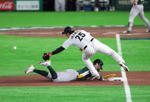 日本対オーストラリア　6回表オーストラリア1死二塁、捕手若月の三塁悪送球でA・ホワイトフィールド（下）の三塁盗塁、先制の生還を許す。三塁手岡本（撮影・足立雅史）