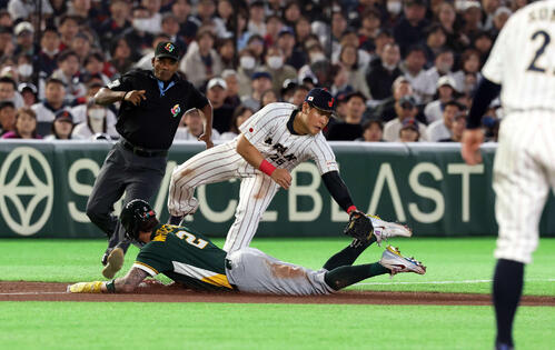日本対オーストラリア　6回表オーストラリア1死二塁、二塁走者ホワイトフィールド（下）の三塁盗塁で、捕手若月の悪送球を岡本は捕れず先制点を許す（撮影・浅見桂子）