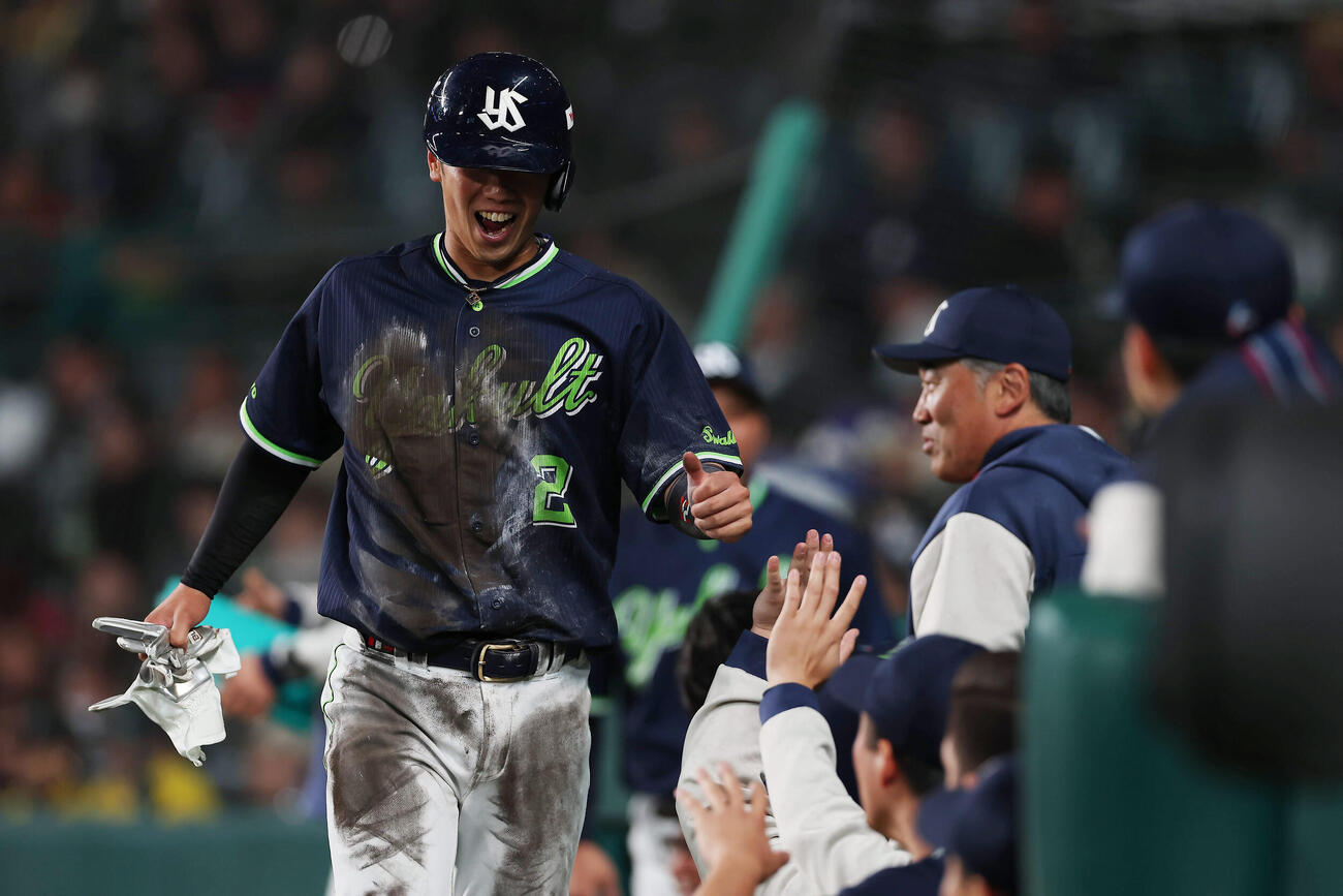 阪神対ヤクルト　6回表ヤクルト2死一、二塁、増田の適時打で生還しナインに迎えられる古賀（撮影・前田充）