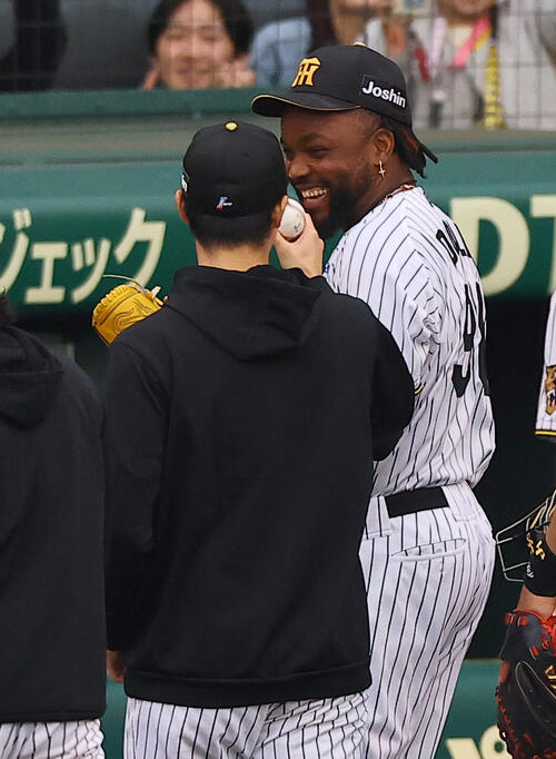 阪神対中日　3勝目を上げた湯浅（左）に笑顔を見せながら勝利球を手渡すドリス（撮影・上田博志）