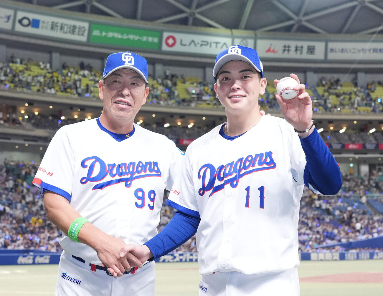 中日対阪神　初勝利の中西聖輝（右）は井上一樹監督とポーズを決める（撮影・森本幸一）