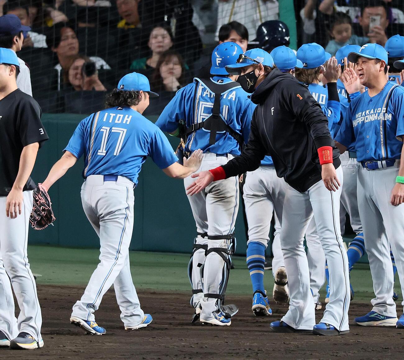 阪神対日本ハム　阪神に勝利し、伊藤大海（左）とタッチする日本ハム新庄剛志監督。通算300勝を達成（撮影・加藤哉）