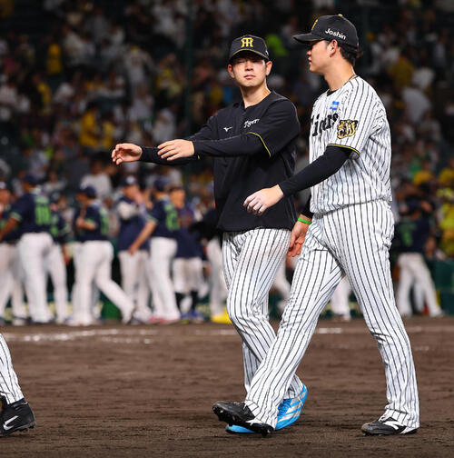 阪神対ヤクルト　プロ初の敗戦投手となった下村海翔（左）は及川雅貴と話しながらベンチに引き揚げる（撮影・上田博志）