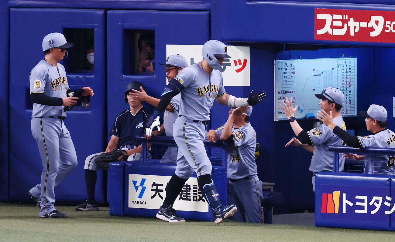 中日対阪神　7回表阪神無死一塁、右中間越え2点本塁打を放った佐藤輝明はベンチの藤川球児監督とタッチ。左は一走森下翔太（撮影・加藤哉）