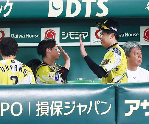 阪神対巨人　8回表を終え、ベンチで梅野隆太郎（左）とタッチする才木浩人（撮影・加藤哉）