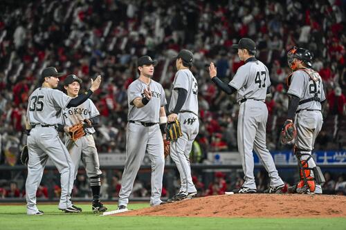 広島に勝利し、タッチを交わす巨人ナイン＝マツダ（共同）