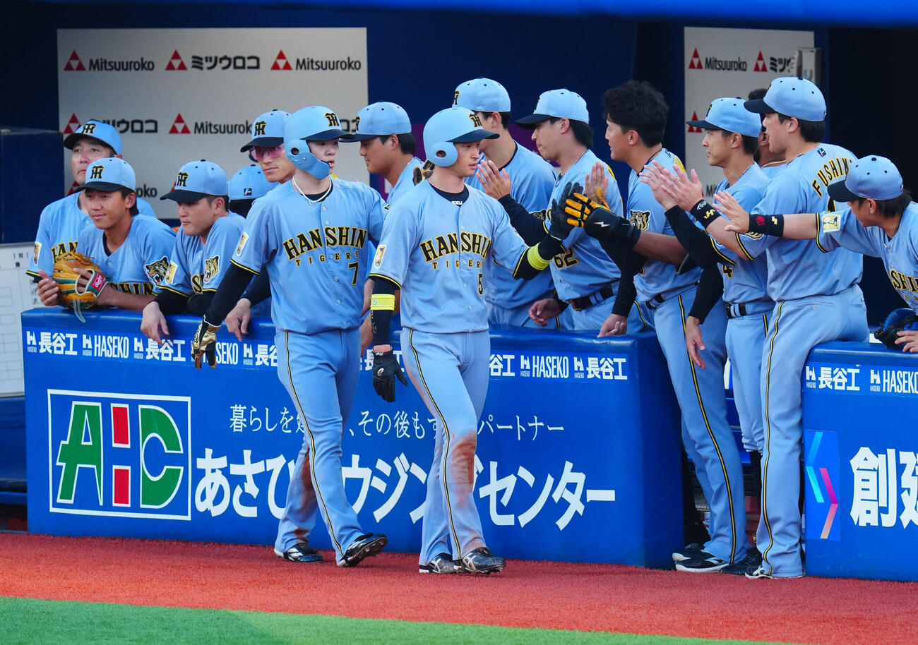 DeNA対阪神　1回表阪神無死一、二塁、森下翔太の先制適時打で生還しナインの出迎えを受ける近本光司（中央右）と中野拓夢（撮影・垰建太）