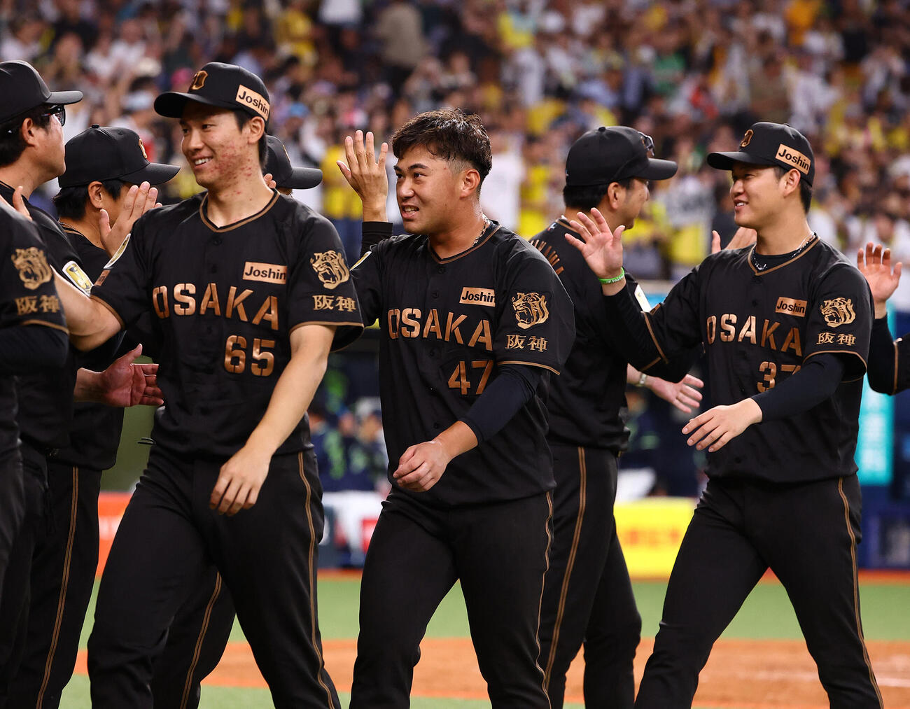 阪神対ヤクルト　ナインとハイタッチする左から湯浅京己、今季初勝利の桐敷拓馬、及川雅貴（撮影・上田博志）