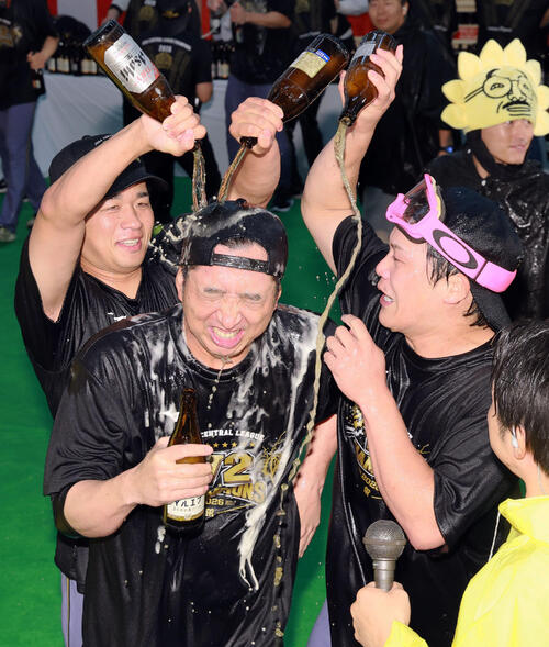 祝勝会で阪神藤川球児監督（手前）にビールをかける高橋遥人（左）と伏見寅威（撮影・上山淳一）