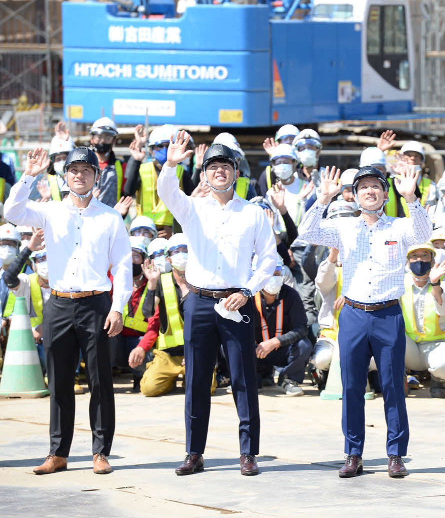 8月24日　北広島にある新球場建設予定地を見学した日本ハムの選手らが上空を飛ぶドローンへ向けて手を振る（手前左から浅間、清水、杉谷）（球団提供）