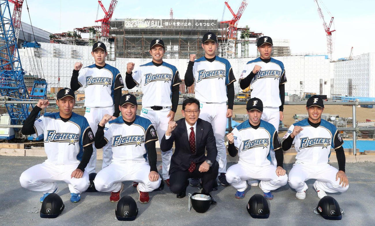 建設中の新球場を背に意気込む日本ハムの新入団選手たち。前列左から、3位古川、1位伊藤、栗山監督、2位五十幡、4位細川、後列左から5位根本、6位今川、育成1位松本遼、育成2位斉藤（撮影・黒川智章）