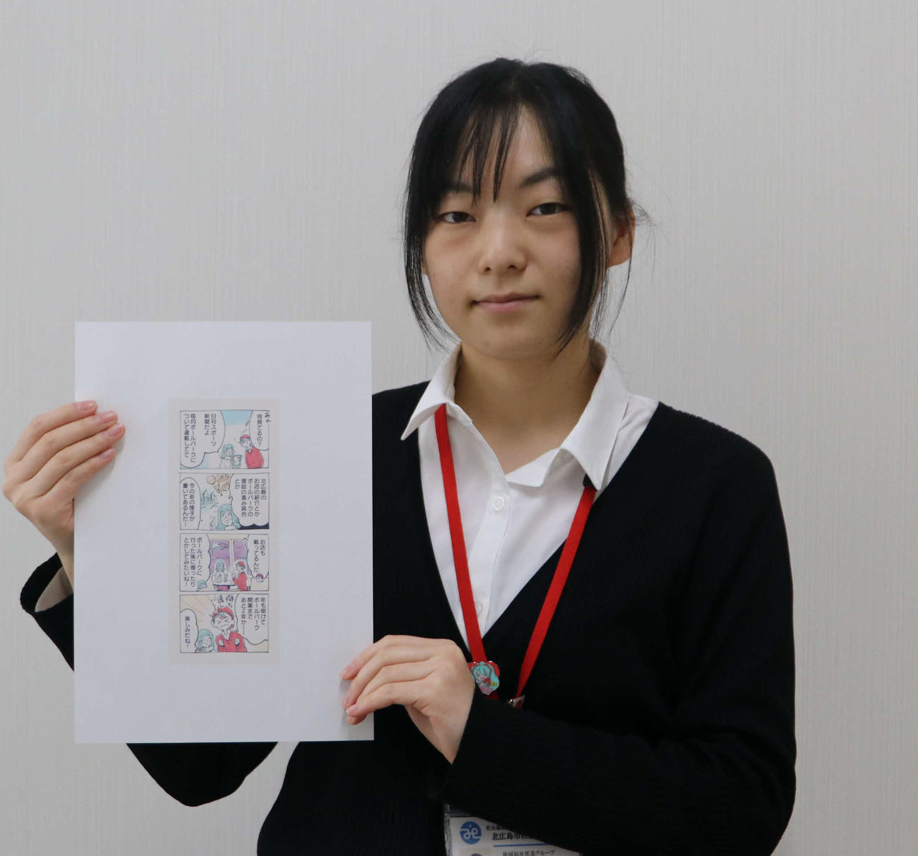 本紙用に描いた4コマ漫画を手にする北広島市ボールパーク推進期成会プロジェクトチームメンバーの香川さん（撮影・山崎純一）