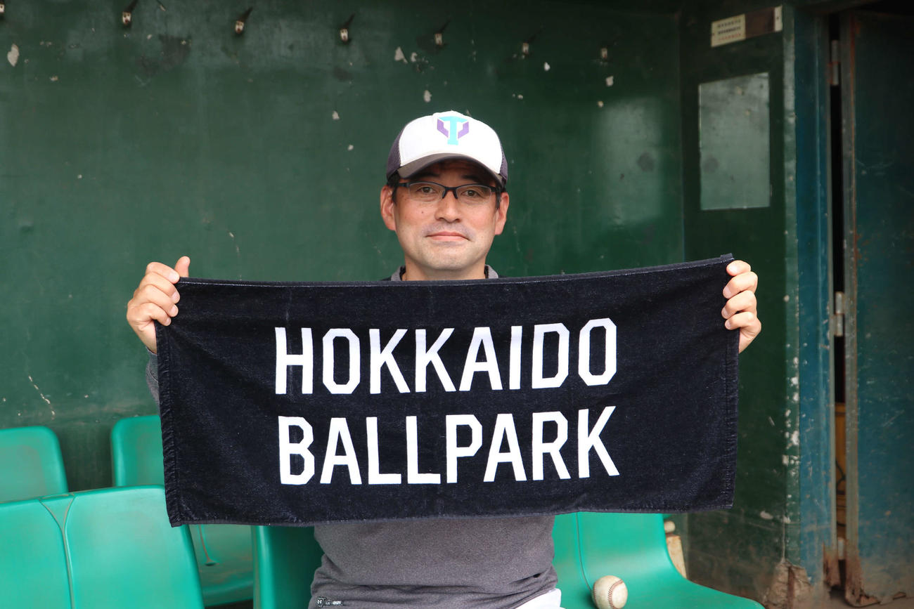 日本ハムのボールパークが印字されたタオルを持つ筑波大准教授の川村氏（撮影・山崎純一）