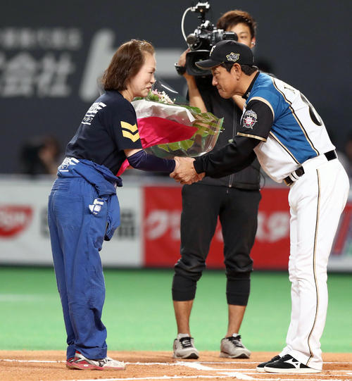 栗山監督から花束を贈られるグラウンドキーパーの工藤さん(2018年3月31日撮影)