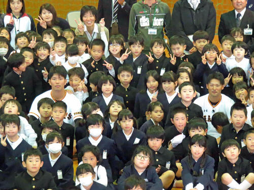 西日本豪雨で被害を受けた岡山・箭田小を訪問した巨人大城卓三捕手（左）と吉川尚輝内野手（右）は児童と記念撮影する(2018年12月5日撮影）
