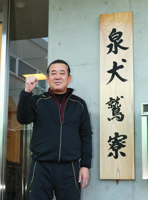 楽天の泉犬鷲寮の前でポーズを決める寮長で元NPB審判員の中村稔氏（撮影・足立雅史）