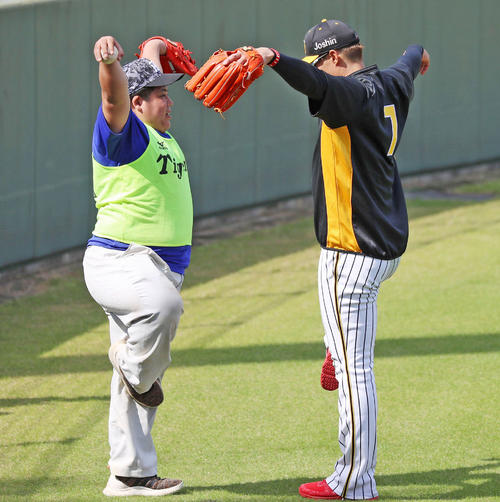 ボール拾いのアルバイトをする當真圭介君(左)は自慢の?!ダンスを披露し糸井嘉男もマネをする(撮影・加藤哉)