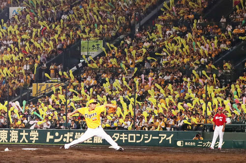 ファンのジェット風船で黄色に染まったスタンドを背に投球する藤川球児