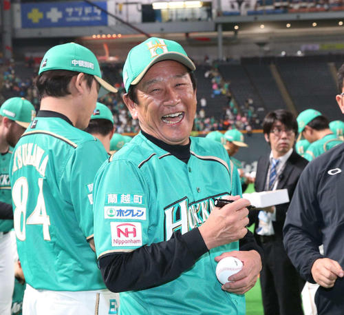 笑顔でボールにサインする栗山監督(2019年5月8日)