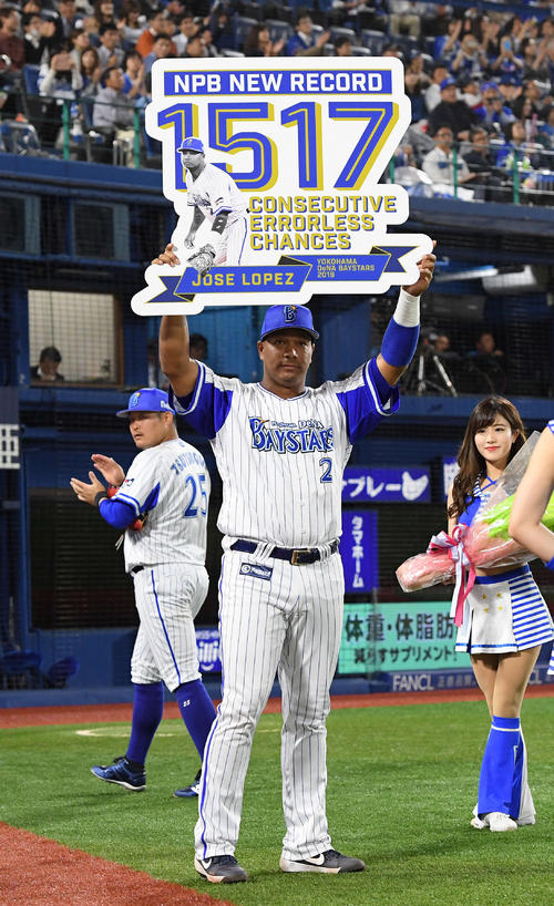 DeNA対中日　一塁守備の連続無失策プロ野球記録を樹立しボードを掲げるDeNAホセ・ロペス。後方は拍手する筒香嘉智（2019年5月16日撮影）