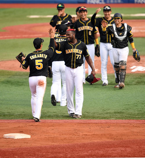 阪神移籍後初勝利を完封で飾り笑顔で近本（左）とタッチを交わすガルシア（手前右）（撮影・横山健太）
