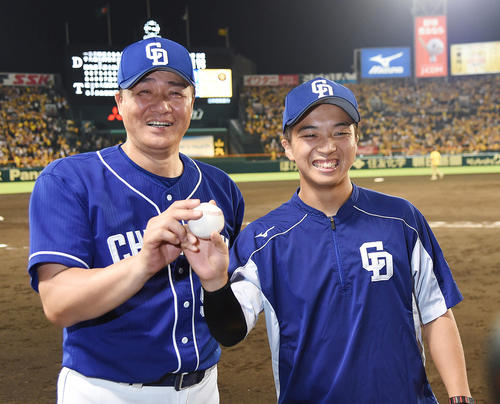 阪神対中日　初勝利をあげた山本（右）は与田監督と笑顔で写真撮影をする（撮影・奥田泰也）